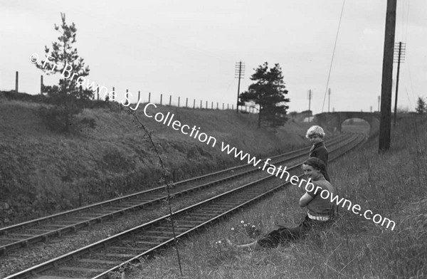 BOYS WATCHING AND WAITING AT RAILWAY EMBANKMENT